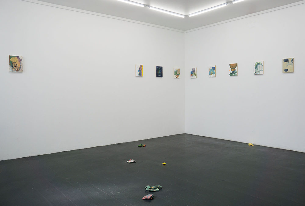 nine paintings on the walls and objects on the floor that look like my wardrobe but shrunk and the colors are faded